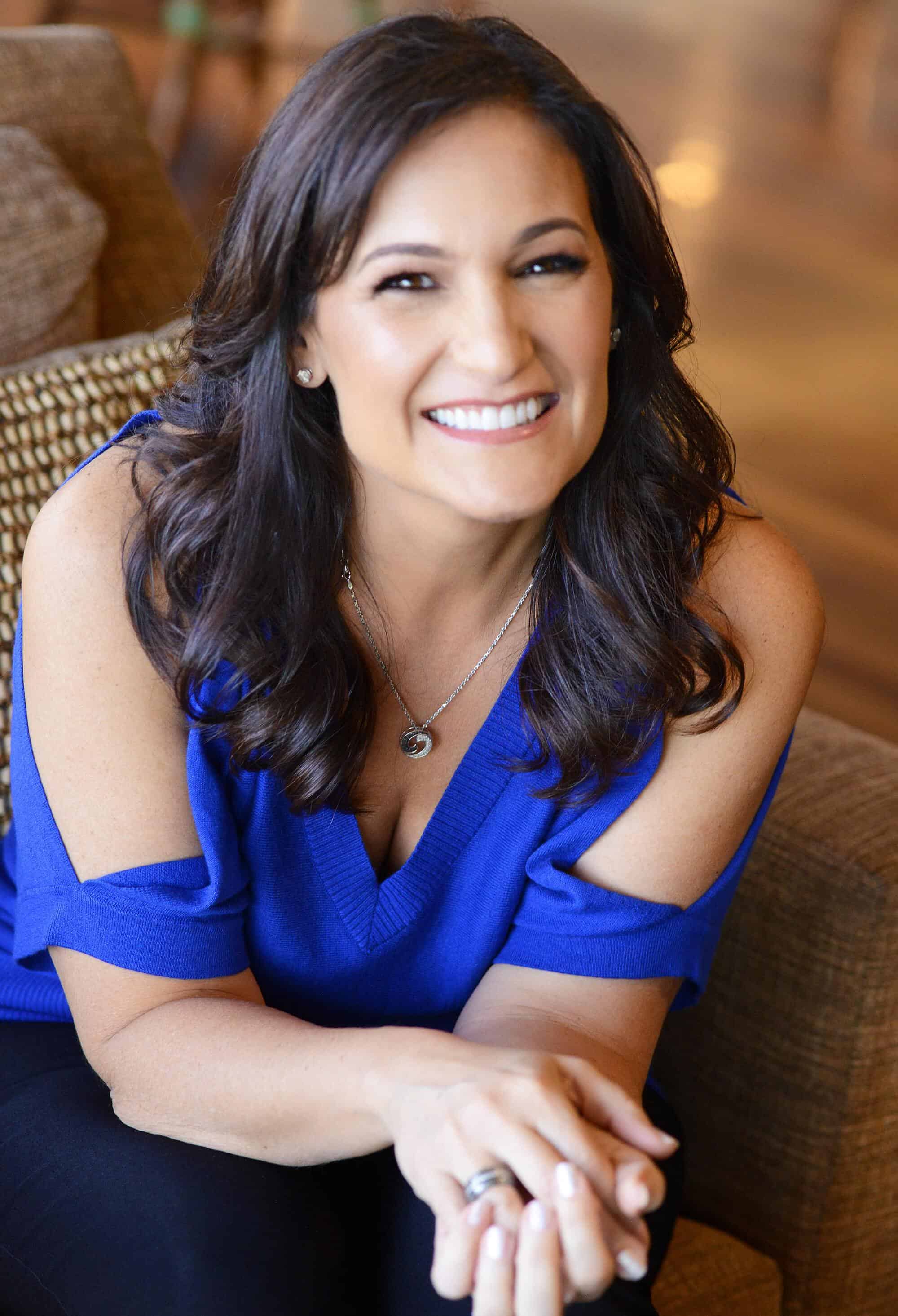 Christy Whitman, an energy master, sitting in a chair smiling