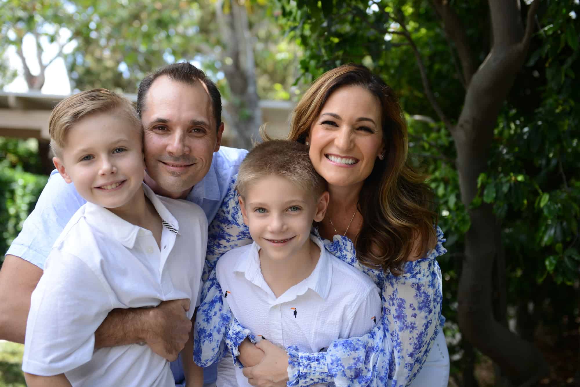 Christy Whitman with her husband and two sons smiling